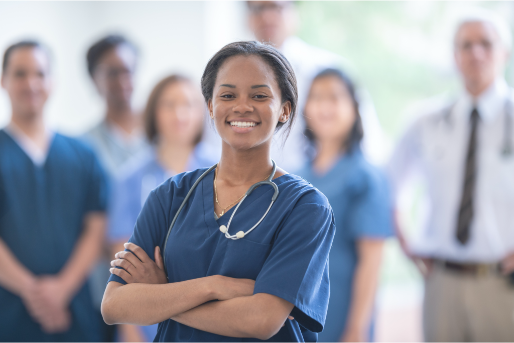 Smiling young female doctor with other doctors in background