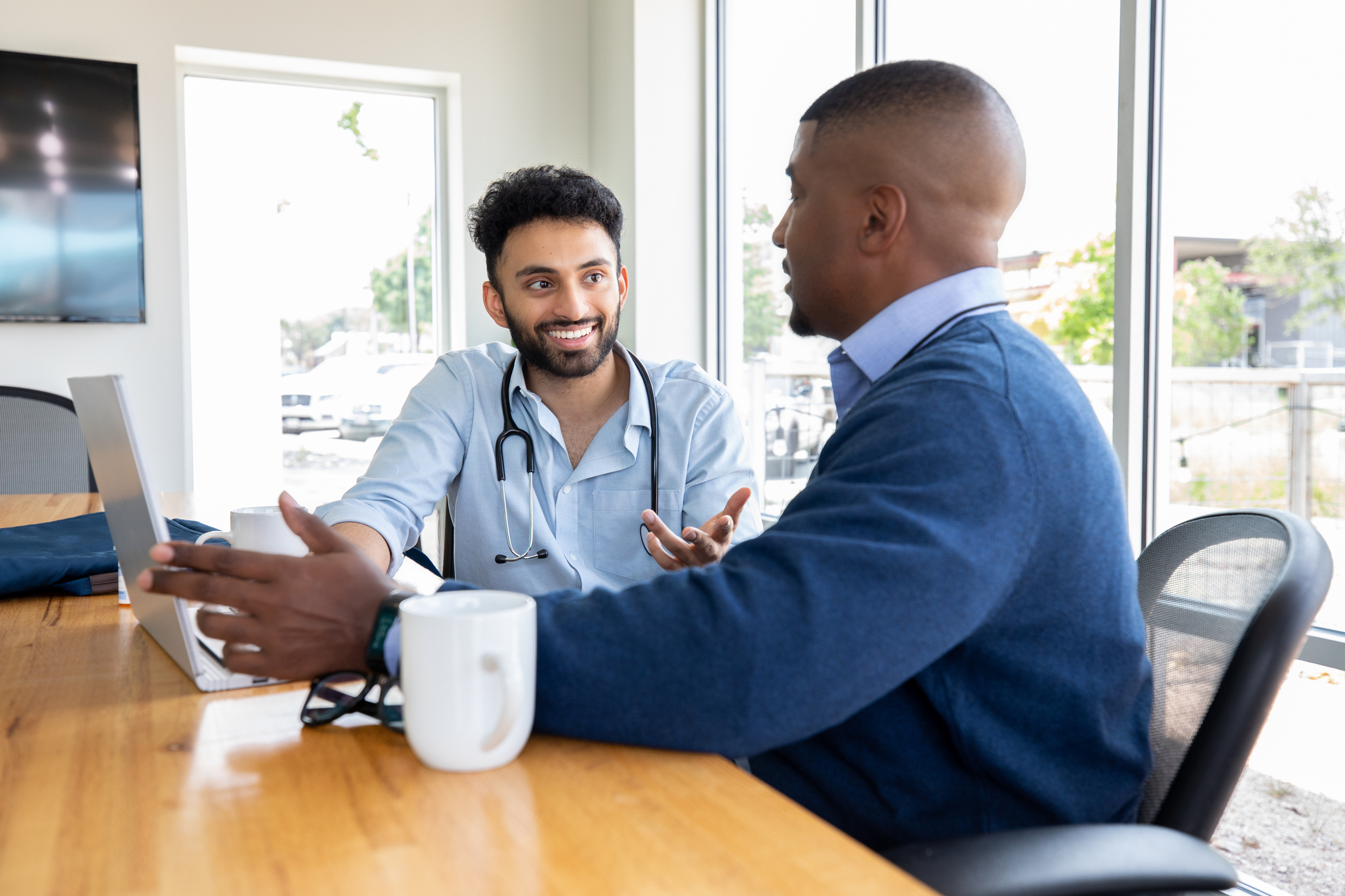Diverse doctors discussing research and patient diagnosis in hospital office